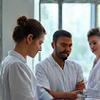 Diverse group of wellness experts collaborating, including a nutritionist, a therapist, and a fitness coach, all looking professional and engaged.