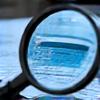 Magnifying glass over scientific research papers and lab reports, symbolizing thorough source verification.